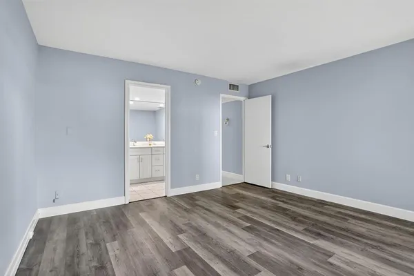 a view of an empty room with wooden floor