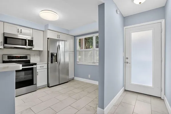 a kitchen with stainless steel appliances granite countertop a refrigerator and a sink