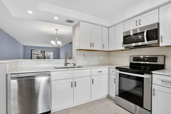 a kitchen with cabinets stainless steel appliances and a sink