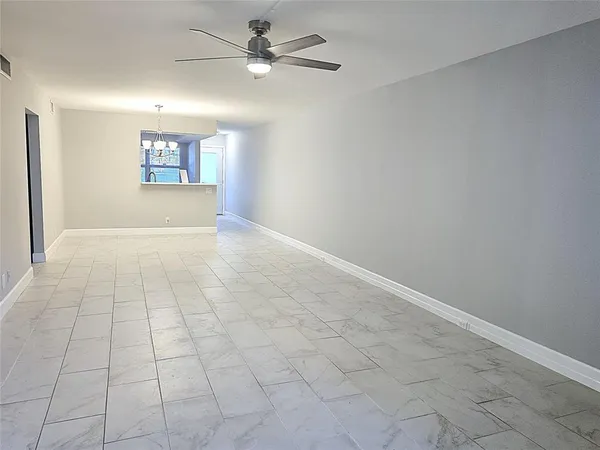 an empty room with fan and windows
