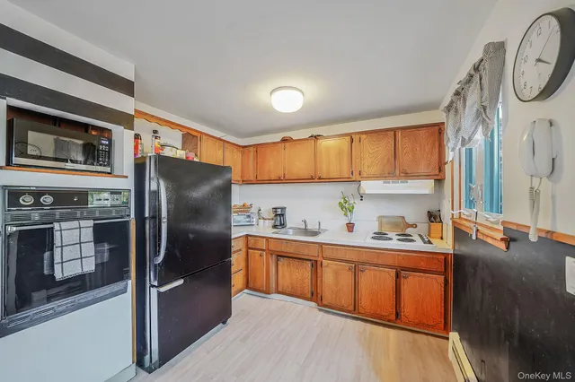 a kitchen with stainless steel appliances granite countertop a refrigerator a sink dishwasher a stove with wooden cabinets and floor