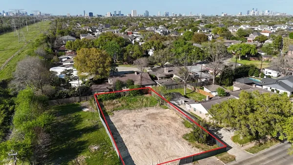 an aerial view of residential houses with outdoor space and trees