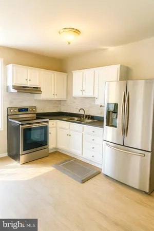 a kitchen with stainless steel appliances granite countertop a stove a refrigerator and a sink
