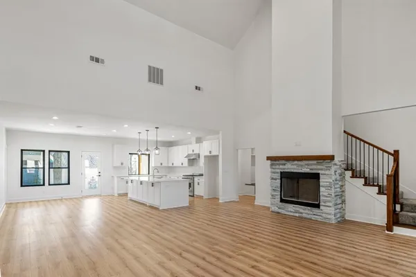 an empty room with wooden floor and fireplace