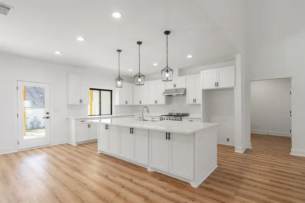 a kitchen with stainless steel appliances granite countertop a sink stove and refrigerator