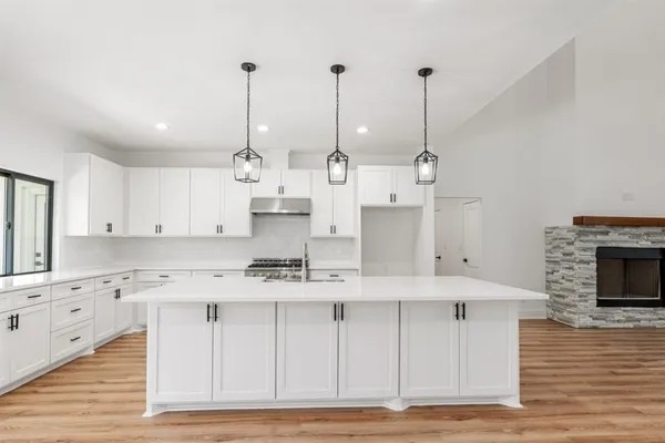 a large white kitchen with lots of counter space a sink and appliances