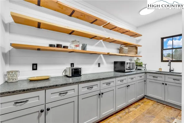 a kitchen with cabinets and wooden floor