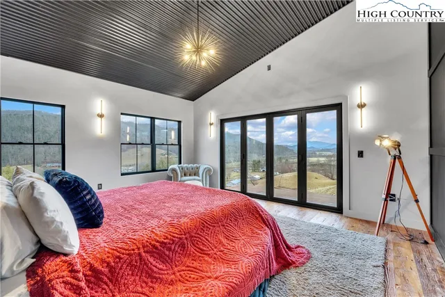 a bed sitting in a spacious bedroom next to a window