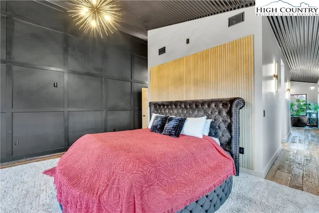 a bed room with a bed and a chandelier