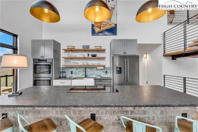 a kitchen with stainless steel appliances granite countertop a stove a sink and a dining table