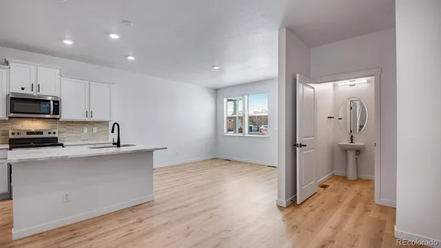 a view of a kitchen with wooden floor and electronic appliances