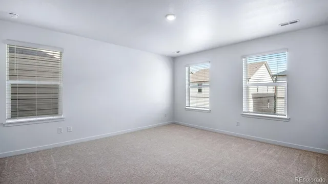 an empty room with windows and closet