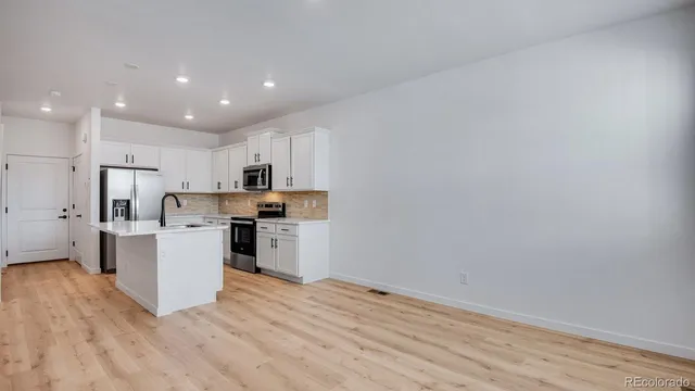 a kitchen with a refrigerator and a stove top oven