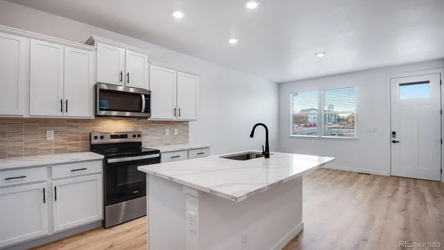a kitchen with granite countertop a stove and a sink