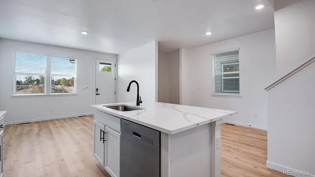 a view of a sink and dishwasher with wooden floor