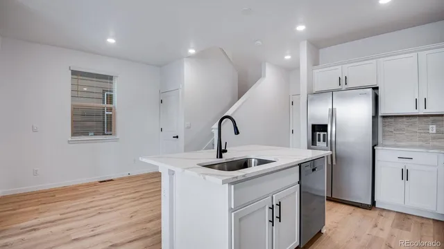 a kitchen with stainless steel appliances granite countertop a refrigerator a sink and a stove