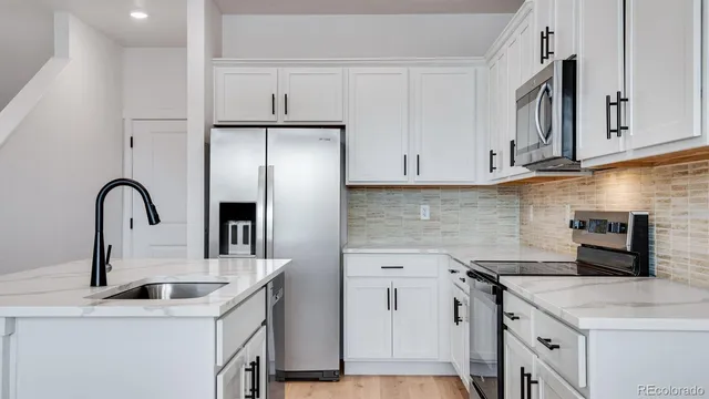 a kitchen with stainless steel appliances granite countertop a sink stove and refrigerator