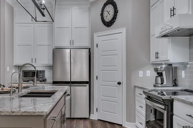 a kitchen with granite countertop a stove and a refrigerator