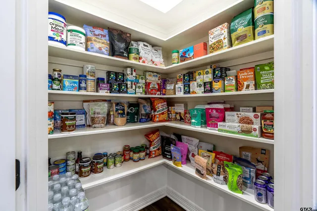a room with lots of books and a refrigerator
