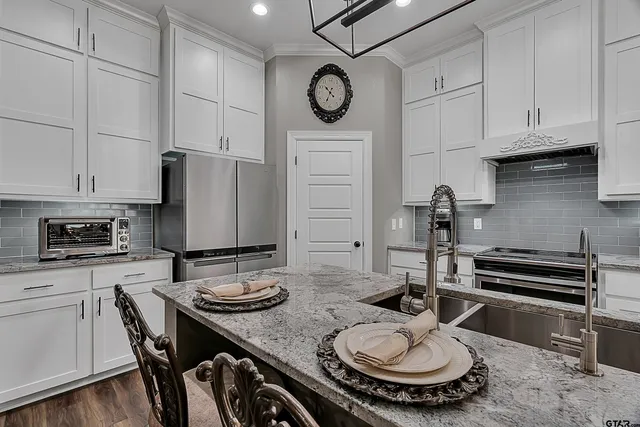 a kitchen with a table chairs and white cabinets