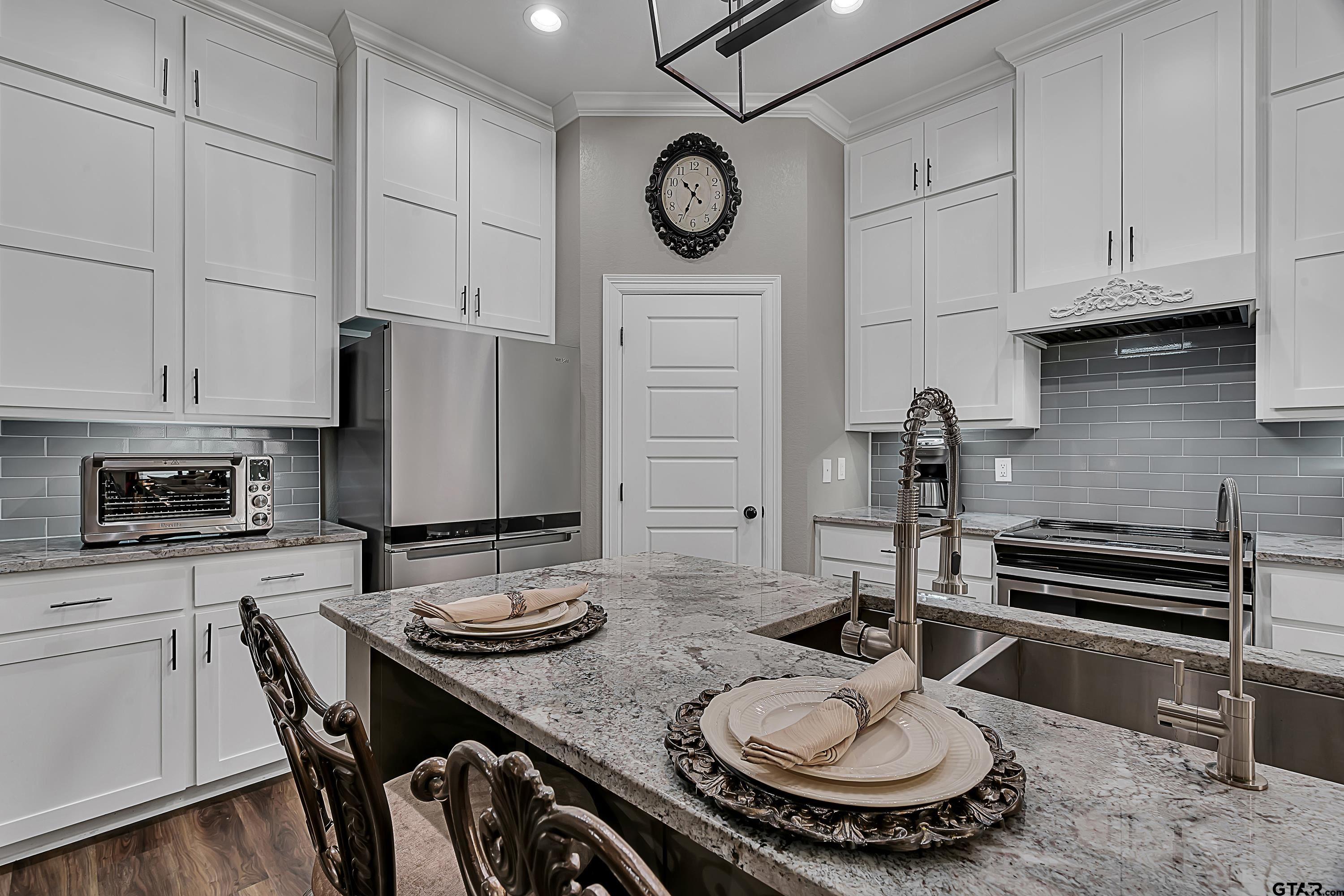 8199 Cr 314 Street South Laneville, TX 75667 - Photo 10 of 47 a kitchen with a table chairs and white cabinets
