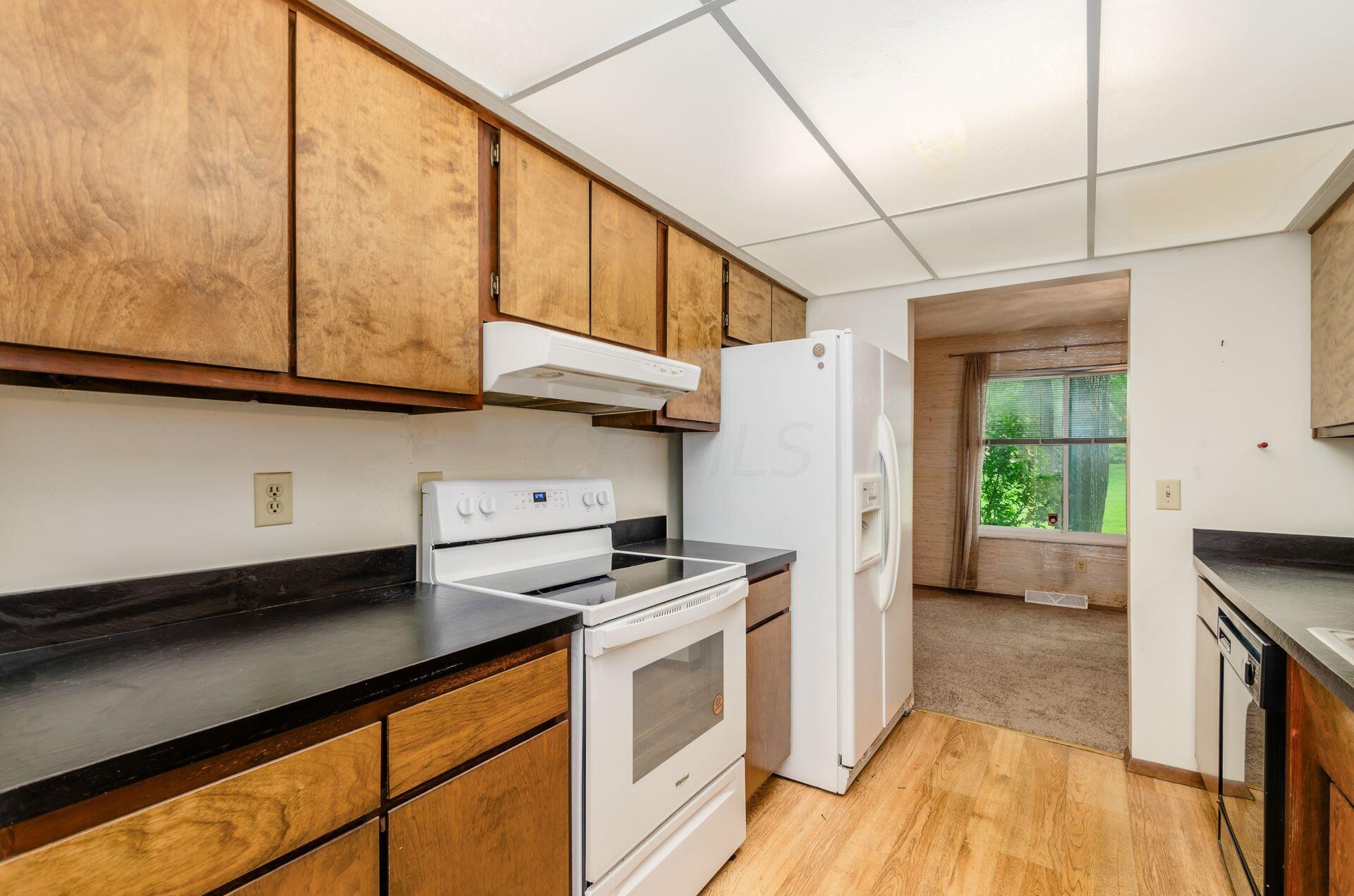 6283 Rutherford Place, Unit A Columbus, OH 43213 - Photo 6 of 33 Natural Raised Wood Cabinetry - New Electric Stove & Oven - White Refrigerator - Black Dishwasher - New Laminate Floor