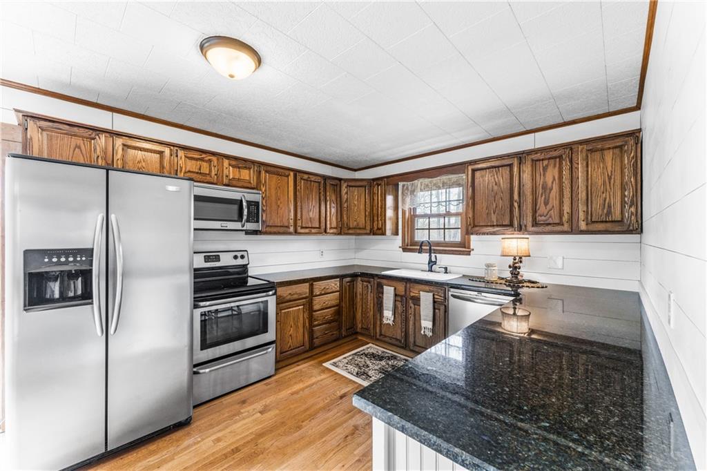 4689 Bell Road Cochranton, PA 16314 - Photo 7 of 32 a kitchen with stainless steel appliances granite countertop a stove a sink and a refrigerator