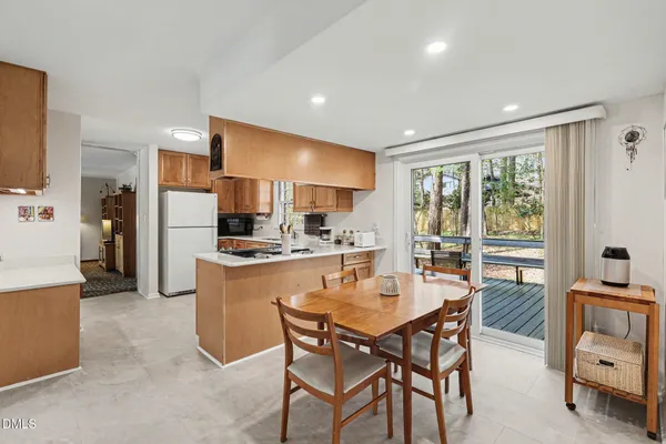 a dining room with kitchen island furniture a large window and kitchen view