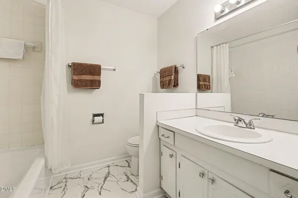 a bathroom with a sink a toilet a mirror and shower