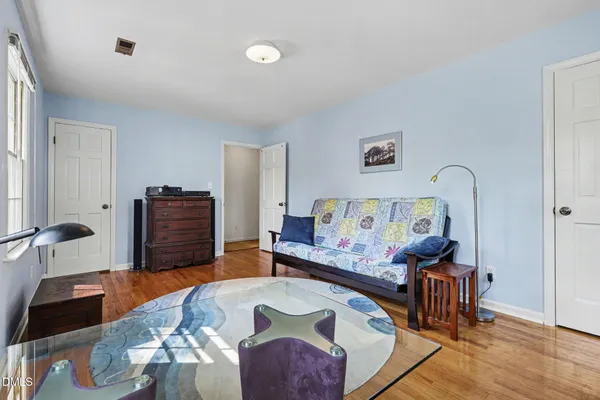 a bedroom with furniture and a wooden floor