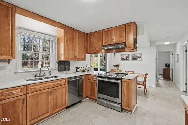 a kitchen with stainless steel appliances granite countertop a sink stove and cabinets
