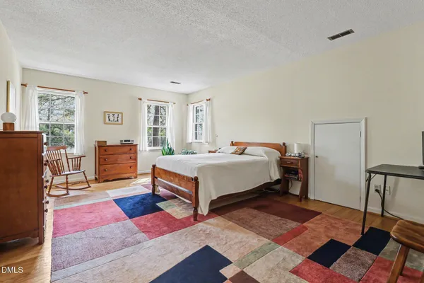 a bedroom with a bed wooden floor and lamp