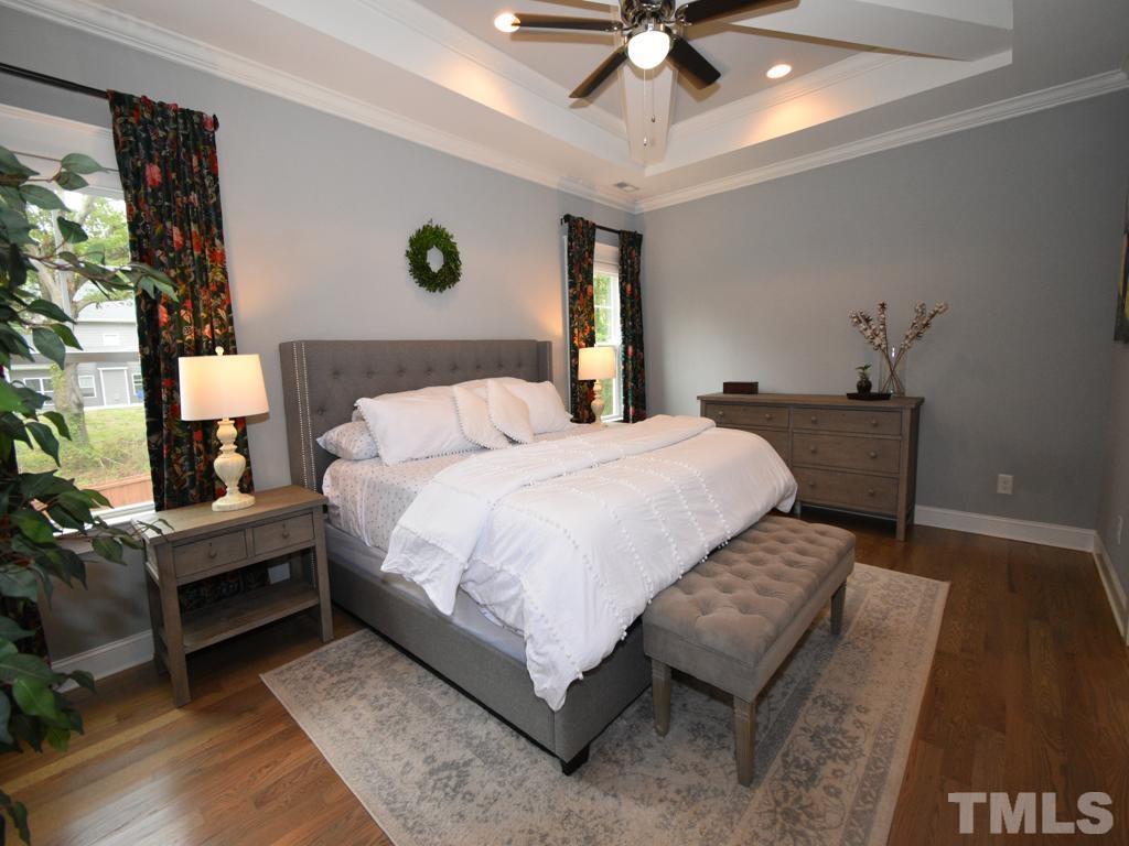 607 Morreene Road Durham, NC 27705 - Photo 30 of 48 a bedroom with a bed and a chandelier