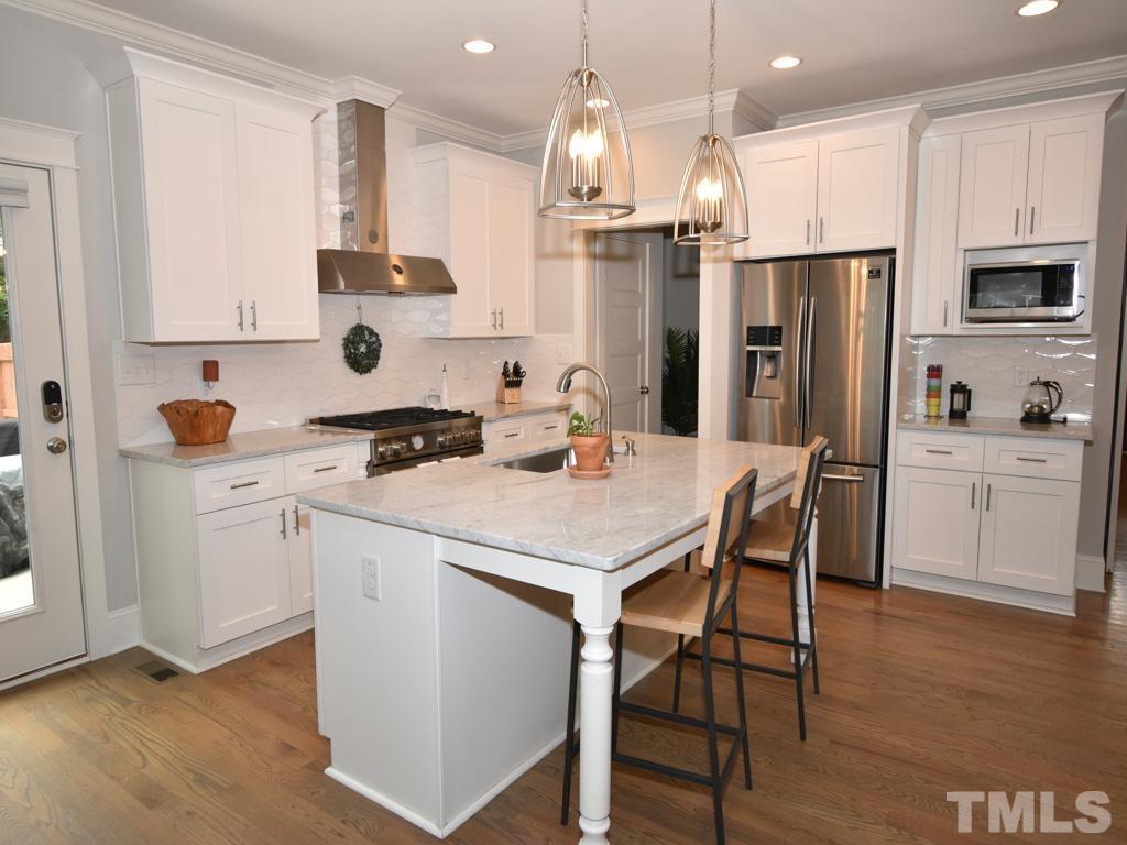 607 Morreene Road Durham, NC 27705 - Photo 3 of 48 a kitchen with white cabinets and stainless steel appliances