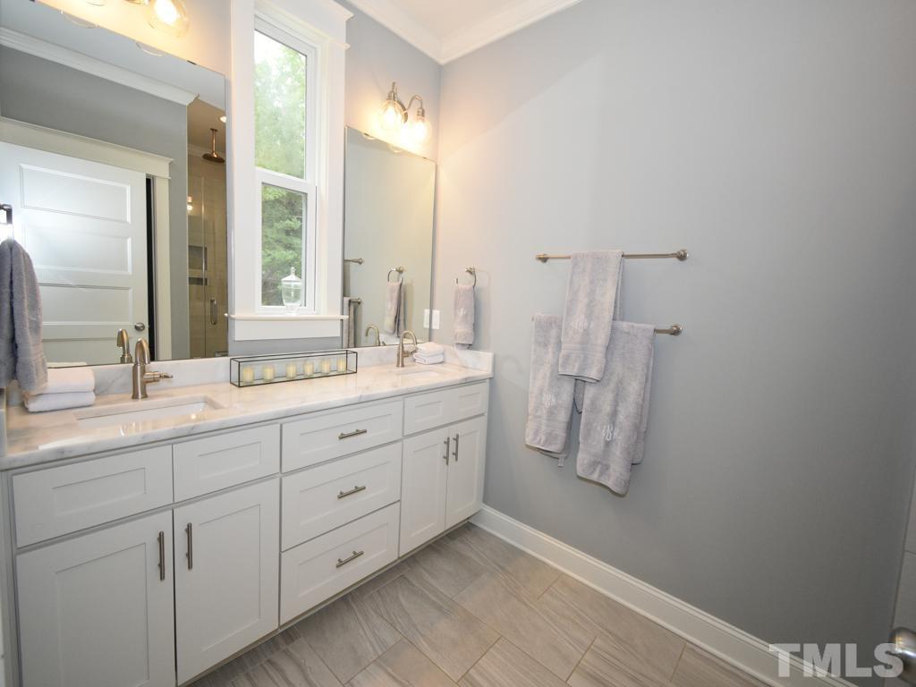 607 Morreene Road Durham, NC 27705 - Photo 33 of 48 a bathroom with a double vanity sink and mirror