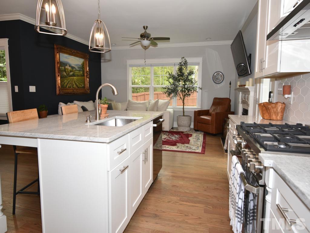 607 Morreene Road Durham, NC 27705 - Photo 4 of 48 a kitchen with stainless steel appliances granite countertop a sink stove and refrigerator