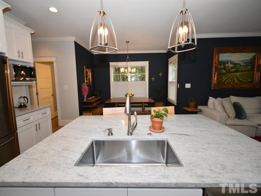 607 Morreene Road Durham, NC 27705 - Photo 5 of 48 a kitchen with kitchen island granite countertop a sink stainless steel appliances and chandelier