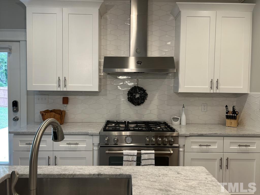 607 Morreene Road Durham, NC 27705 - Photo 6 of 48 a kitchen with stainless steel appliances granite countertop a stove and a white cabinets