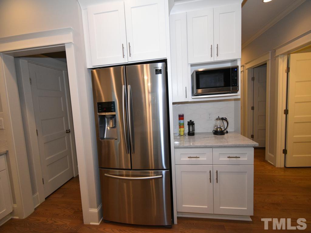 607 Morreene Road Durham, NC 27705 - Photo 8 of 48 a kitchen with stainless steel appliances white cabinets and wooden floor