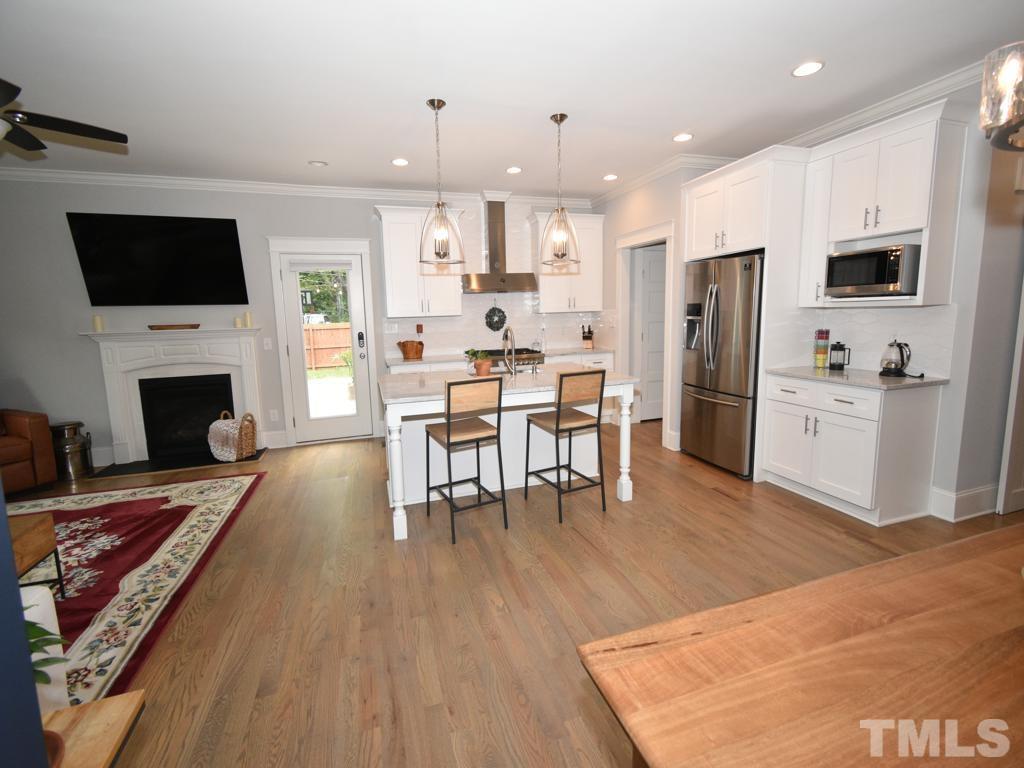 607 Morreene Road Durham, NC 27705 - Photo 9 of 48 a living room with fireplace furniture and a flat screen tv