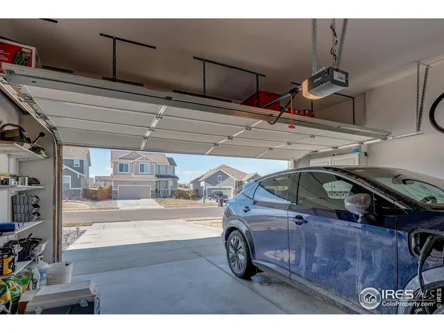 a view of garage with a car parked on the road