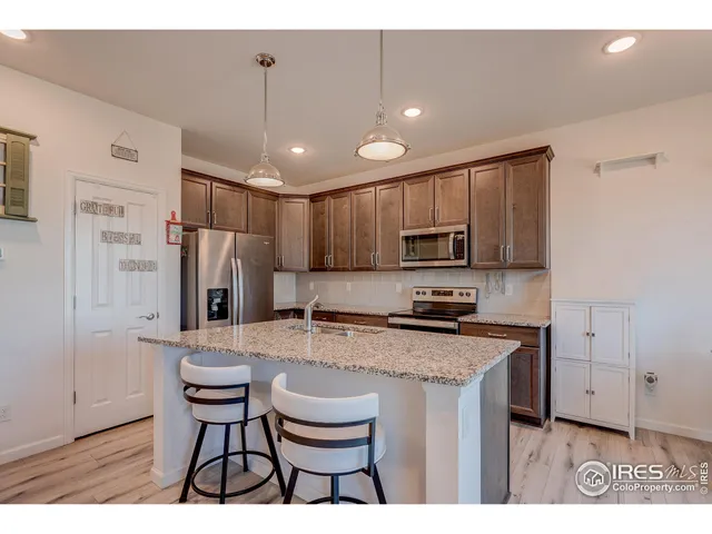a kitchen with refrigerator a stove and chairs