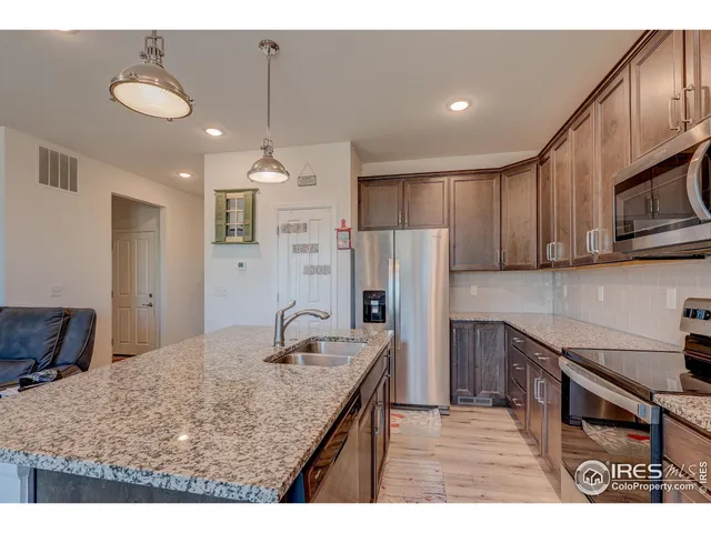 a kitchen with kitchen island a sink stove and refrigerator
