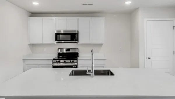 a kitchen with kitchen island a sink stainless steel appliances and cabinets