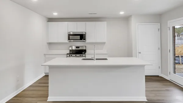 a kitchen with kitchen island stainless steel appliances a sink and a refrigerator