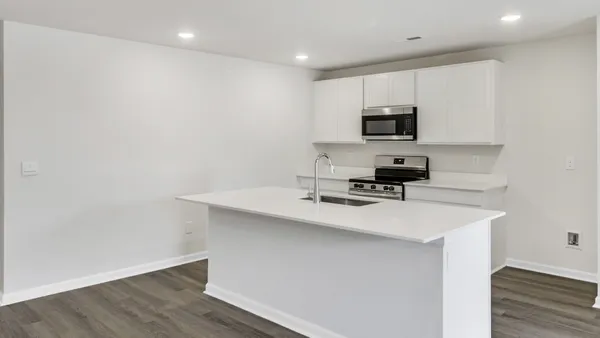 a kitchen with a sink a microwave and cabinets