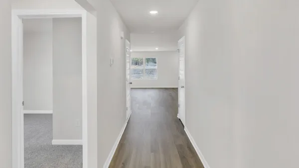 a view of a hallway with wooden floor