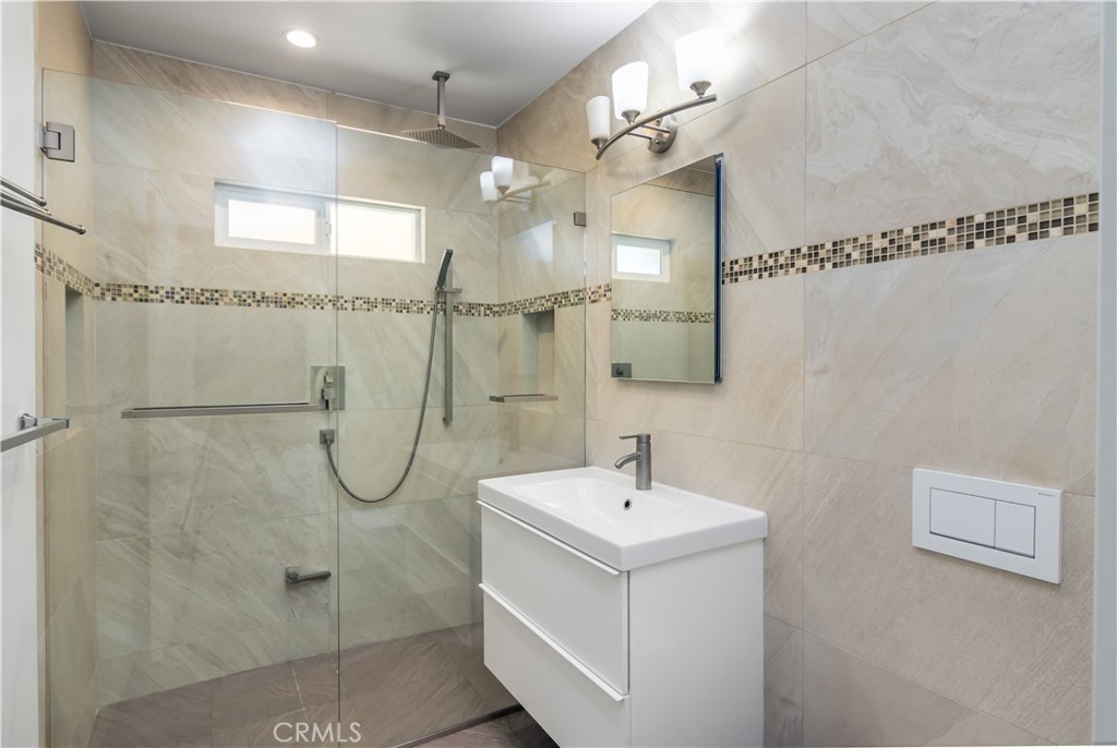15439 Vose Street Van Nuys, CA 91406 - Photo 17 of 22 a bathroom with a shower sink and mirror