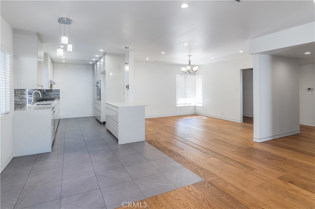 15439 Vose Street Van Nuys, CA 91406 - Photo 5 of 22 a room with a wooden floor and white cabinets
