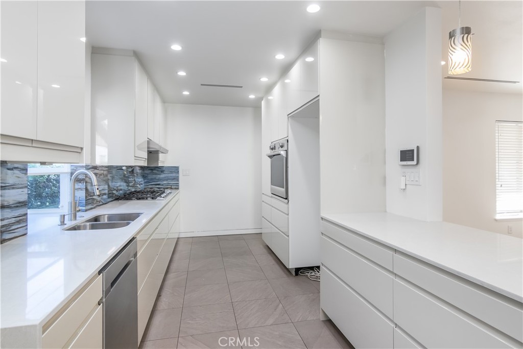 15439 Vose Street Van Nuys, CA 91406 - Photo 9 of 22 a kitchen with a sink stove and refrigerator